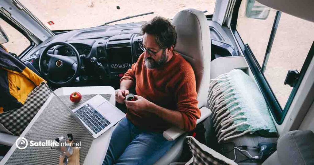 male drinking espresso in an RV using a laptop to surf the internet